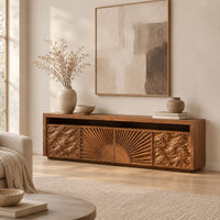 Tv stand with a carved sunburst center and wave relief side panels in a Scandinavian living room with white walls