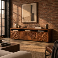 Tv stand with a carved sunburst center and wave relief side panels in an industrial loft living room with exposed brick