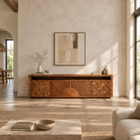 Tv stand with a carved sunburst center and wave relief side panels in a bright open plan living room