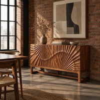 Sideboard with sunburst carving across the front on a slim open frame base in an industrial loft dining room with exposed brick