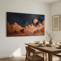 Sunrise mountain wall sculpture with a dark carved sky beside a dining table in natural light
