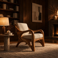 Wooden armchair with sweeping looped arms and soft cream cushions in an evening living room with walnut wall paneling