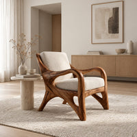 Wooden armchair with sweeping looped arms and soft cream cushions in a Scandinavian living room with white walls