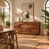 Three door sideboard carved with one long curling wave in a bright dining room with arched windows and plants