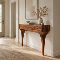 Console table with two front panels and sweeping tapered legs in a Scandinavian entryway with white walls