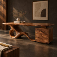 Corner detail of long desk with a swooping loop base and a wave carved cabinet beside wood, brass and linen samples