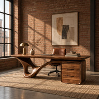 Desk with a looping sculpted leg and a three drawer pedestal in an industrial loft home office with exposed brick