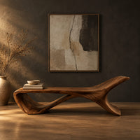 Low sweeping bench with an open loop underside and a raised end in a dark studio against a charcoal plaster wall