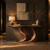 Console table with a slim top on one sweeping sculpted pedestal in a dark entryway at golden hour