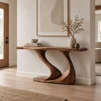 Console table with a slim top on one sweeping sculpted pedestal in a Scandinavian entryway with white walls