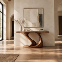 Console table with a slim top on one sweeping sculpted pedestal in a bright open plan entryway