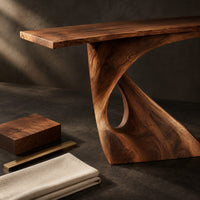 Corner detail of console table with a slim top on a single pedestal pierced by a teardrop beside wood, brass and linen samples