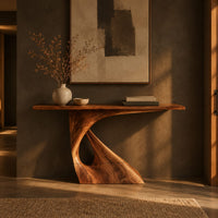 Console table with a slim top on a single pedestal pierced by a teardrop in a dark entryway at golden hour