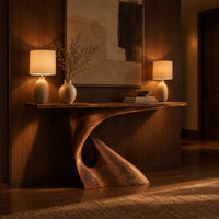 Console table with a slim top on a single pedestal pierced by a teardrop in an evening entryway with walnut wall paneling