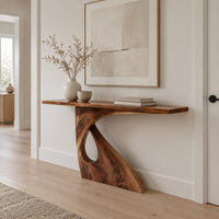 Console table with a slim top on a single pedestal pierced by a teardrop in a Scandinavian entryway with white walls