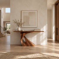 Console table with a slim top on a single pedestal pierced by a teardrop in a bright open plan entryway