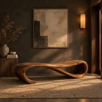 Long wooden bench shaped like a ribbon with a rolled end in a dark entryway at golden hour