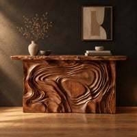 Console table with a swirl carved front and a thick natural edge top in a dark studio against a charcoal plaster wall