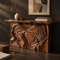 Corner detail of console table with a swirl carved front and a thick natural edge top beside wood, brass and linen samples
