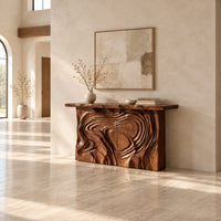 Console table with a swirl carved front and a thick natural edge top in a bright open plan entryway