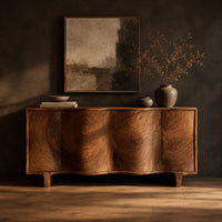 Wavy front sideboard with four panels of swirling wood grain in a dark studio against a charcoal plaster wall