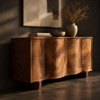 Corner detail of wavy front sideboard with four panels of swirling wood grain beside wood, brass and linen samples