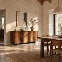 Wavy front sideboard with four panels of swirling wood grain in a bright open plan dining room
