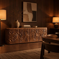 Long sideboard with four doors carved in deep swirling ripples in an evening dining room with walnut wall paneling
