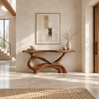 Console table with a slim plank top on a swirling sculpted base in a bright open plan entryway