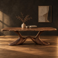Dining table with a soft edged top on a swooping wave base in a dark studio against a charcoal plaster wall