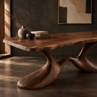 Corner detail of dining table with a soft edged top on a swooping wave base beside wood, brass and linen samples