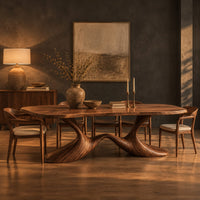Dining table with a soft edged top on a swooping wave base in a dark dining room at golden hour