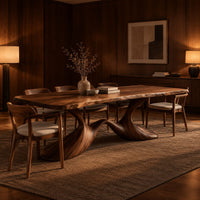 Dining table with a soft edged top on a swooping wave base in an evening dining room with walnut wall paneling