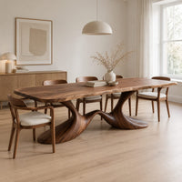 Dining table with a soft edged top on a swooping wave base in a Scandinavian dining room with white walls