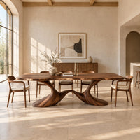 Dining table with a soft edged top on a swooping wave base in a bright open plan dining room