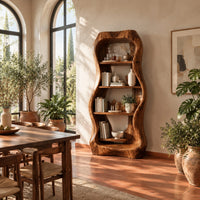 Tall bar cabinet with a thick wavy frame and open shelves in a bright dining room with arched windows and plants
