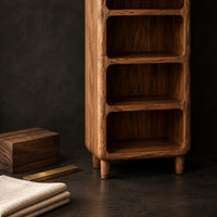 Corner detail of tall open shelf cabinet with five bays and softened corners beside wood, brass and linen samples
