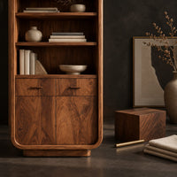 Corner detail of tall bathroom cabinet with four open shelves above two small drawers and two doors beside wood, brass and linen samples