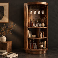 Corner detail of tall cylinder bar cabinet with a glass rail on top and open cubbies below beside wood, brass and linen samples