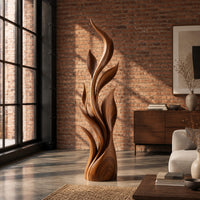 Tall flame sculpture of layered leaf blades rising from a smooth base in an industrial loft living room with exposed brick