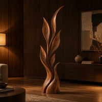 Wood sculpture of a slim leafy stem with pointed leaves and a sculpted base in an evening living room with walnut wall paneling