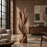Wood sculpture of a slim leafy stem with pointed leaves and a sculpted base in an industrial loft living room with exposed brick