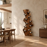 Tall live edge slab wine rack with angled bottle pegs in a bright open plan dining room