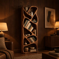 Tall narrow wooden bookshelf with slanted dividers and flowing open cubbies in an evening living room with walnut wall paneling