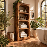 Tall open shelf cabinet with four carved niches and textured grain in a bright bathroom with arched windows and plants
