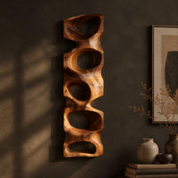 Tall wooden wall sculpture with five stacked organic openings, three-quarter view showing the carved depth