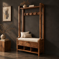 Corner detail of tall wood storage bench with coat hooks and three open cubbies beside wood, brass and linen samples