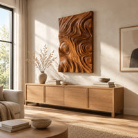 Tall wood wall art panel with sculpted ripples and a ringed knot above a light oak sideboard in daylight