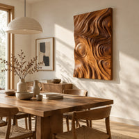 Tall wood wall art panel with sculpted ripples and a ringed knot beside a dining table in natural light