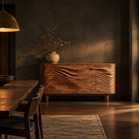 Sideboard with four wave carved doors and tapered legs in a dark dining room at golden hour